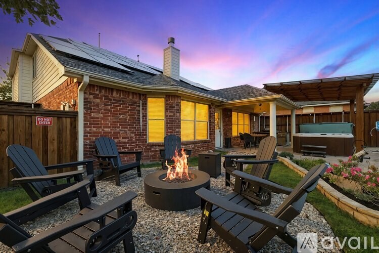 A backyard with a fire pit and chairs.