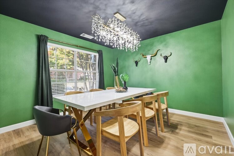 A dining room with a white table and chairs.