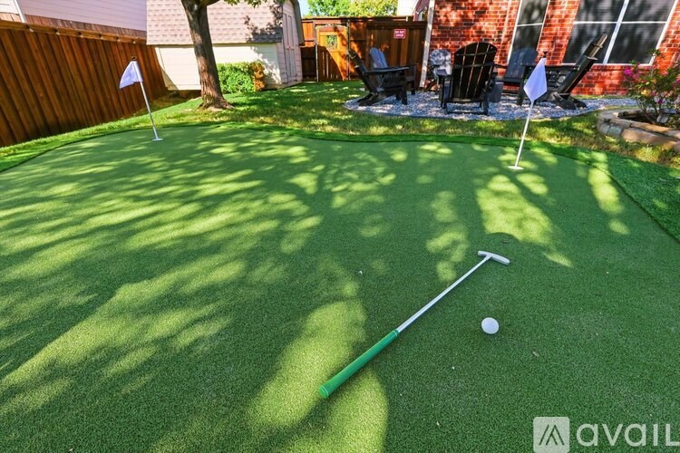 A miniature golf course with a white ball and a green flag.
