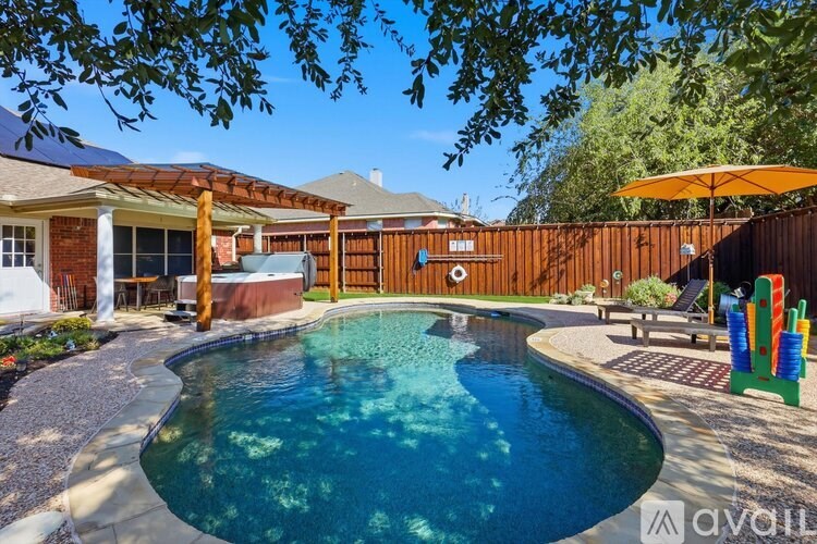 A backyard with a kidney-shaped pool and a wooden fence.