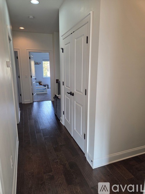 A tree in a yard with a car parked in the background.