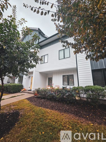 A white house with a tree in front of it.