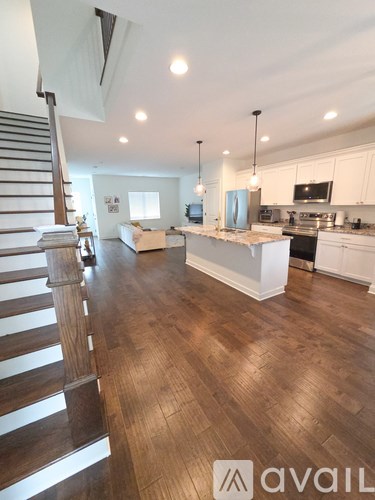 A kitchen with a stainless steel refrigerator and white cabinets.