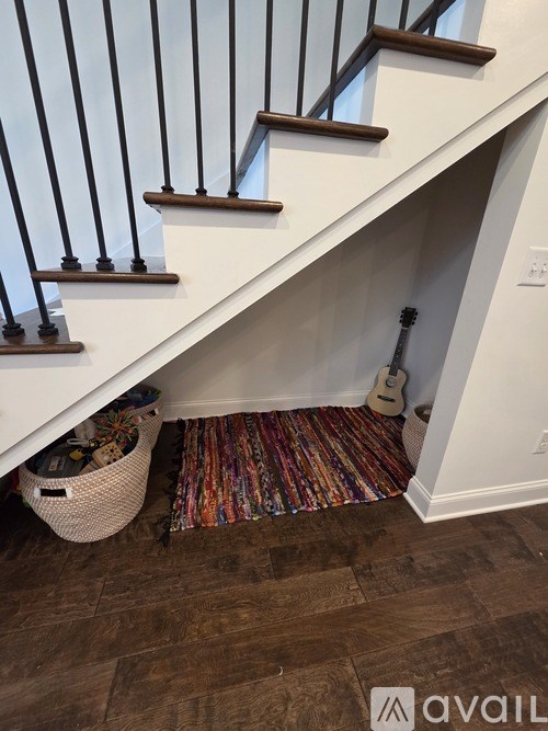 A guitar is tucked under the stairs.