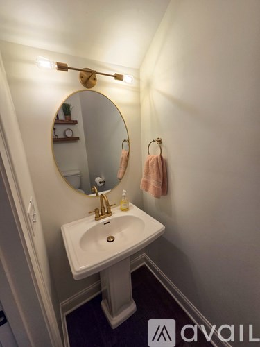 A white room with a table and chair and a rug.