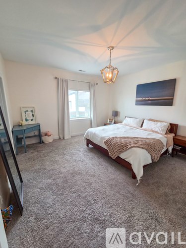 A bedroom with a large bed and a chandelier.