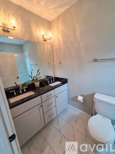 A bathroom with a toilet, sink, and mirror.