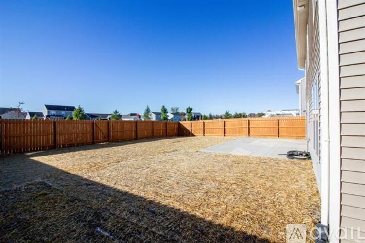 A backyard with a fence and a clear blue sky.