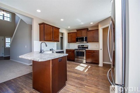 A kitchen with a marble countertop and wooden cabinets.