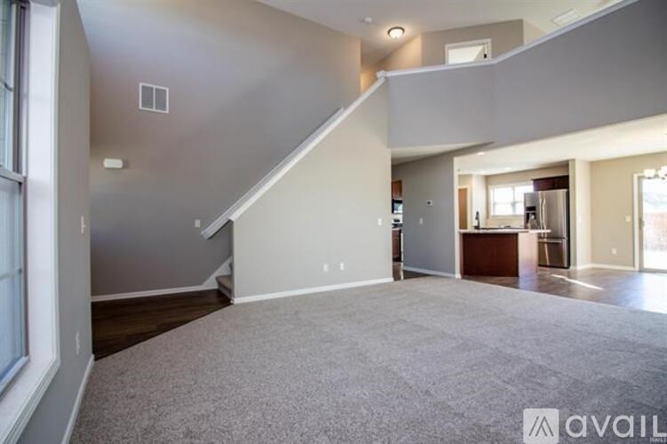 A spacious living room with a staircase leading to the upper level.