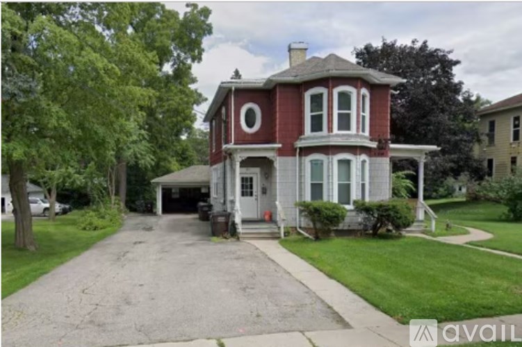 A red and white house with a gravel driveway in front.