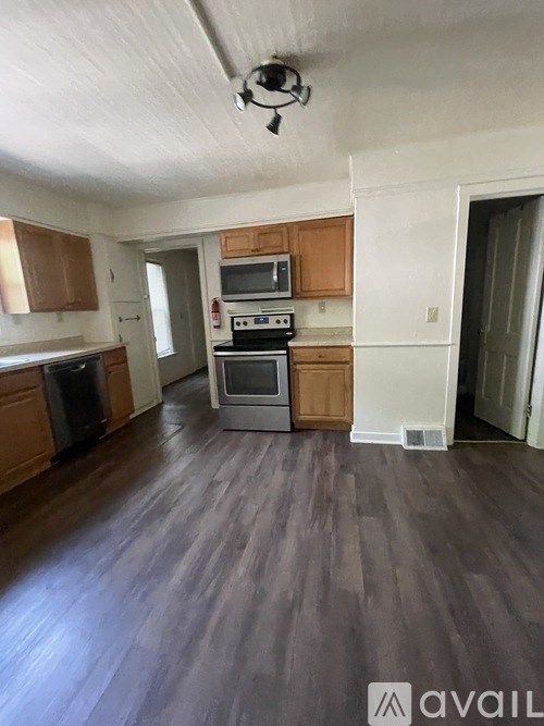 A kitchen with wooden cabinets and a stove top oven.