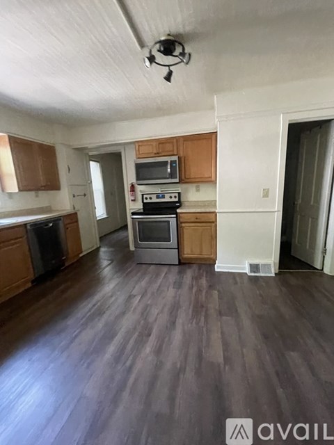 A kitchen with wooden cabinets and a stove top oven.
