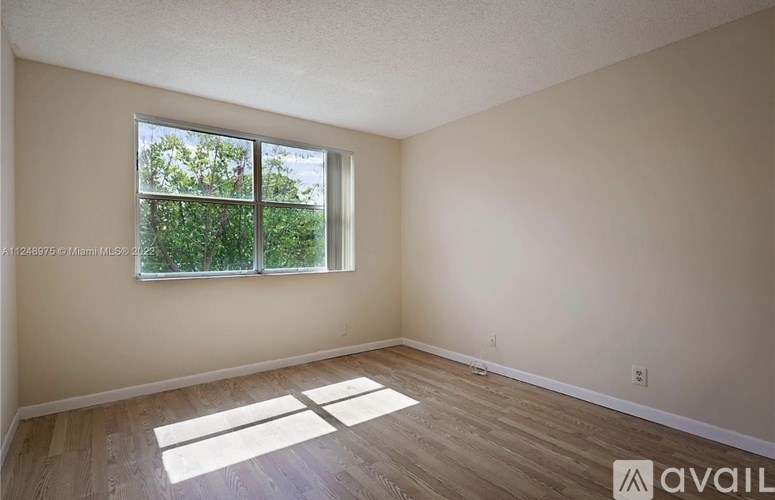 A room with a window and wooden flooring is available for rent.