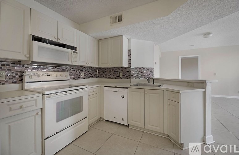 A kitchen with white appliances and cabinets.