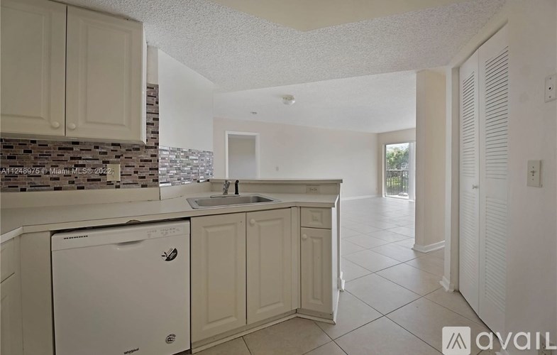 A kitchen with white cabinets and a dishwasher.