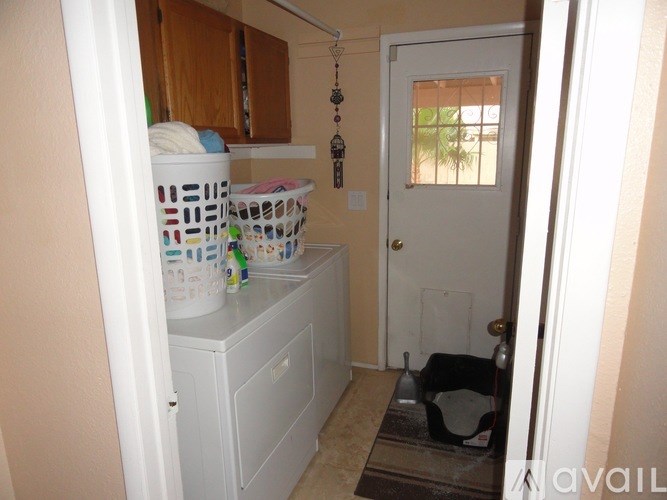A laundry room with a white cabinet and a door.