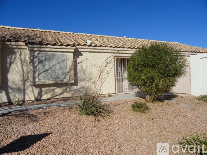 A house with a brown roof and a tree in front.