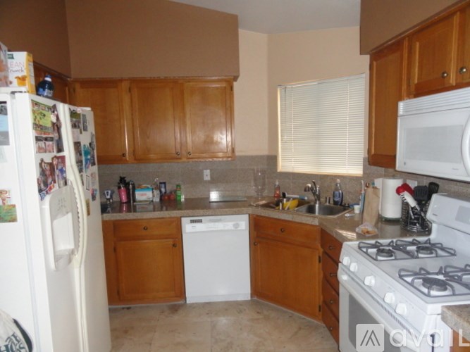 A kitchen with white appliances and wooden cabinets.