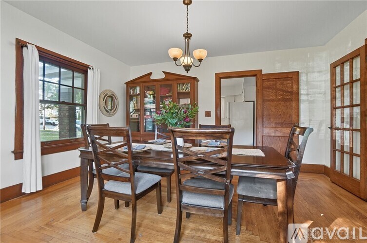 A dining room with a wooden table and chairs.