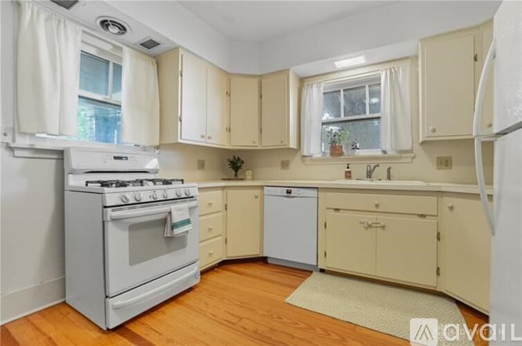 A kitchen with a white stove and cabinets.