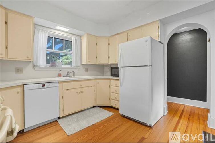 A kitchen with wooden floors and white appliances.