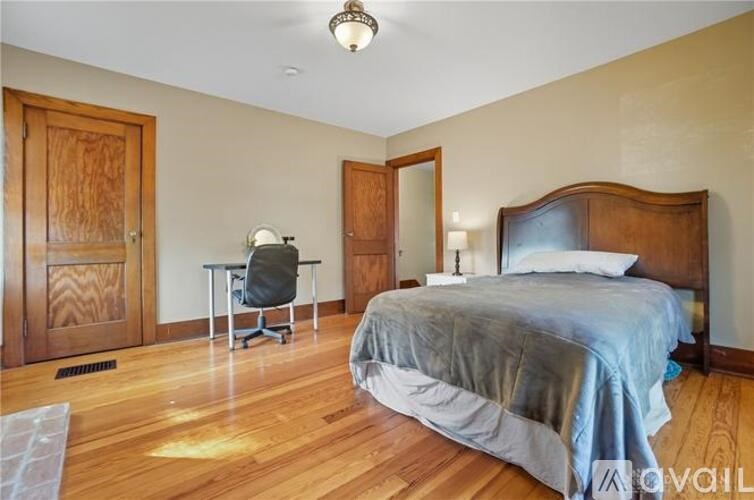 A bedroom with a bed, desk, and chair.