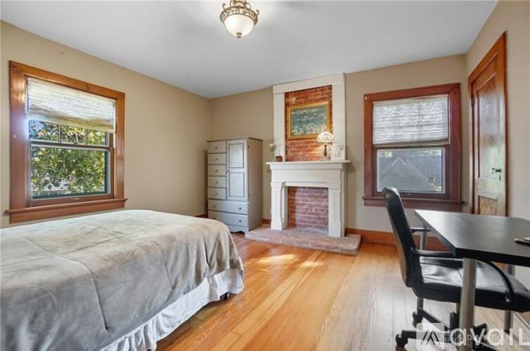 A bedroom with a bed, desk, and chair.