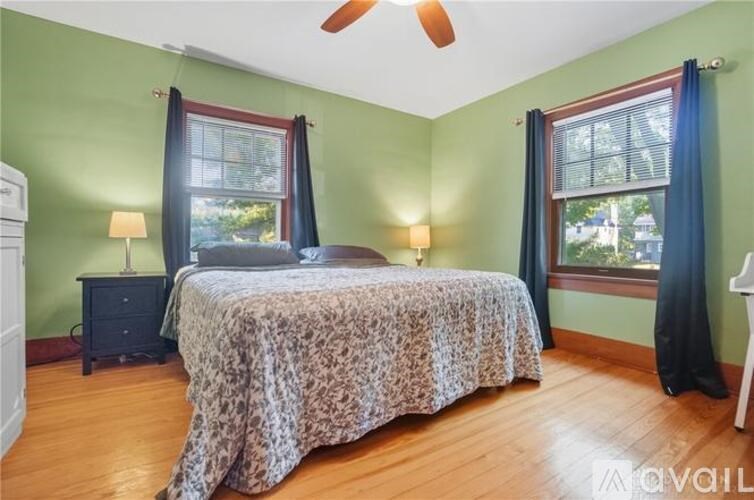 A bedroom with a bed, two lamps, and a ceiling fan.
