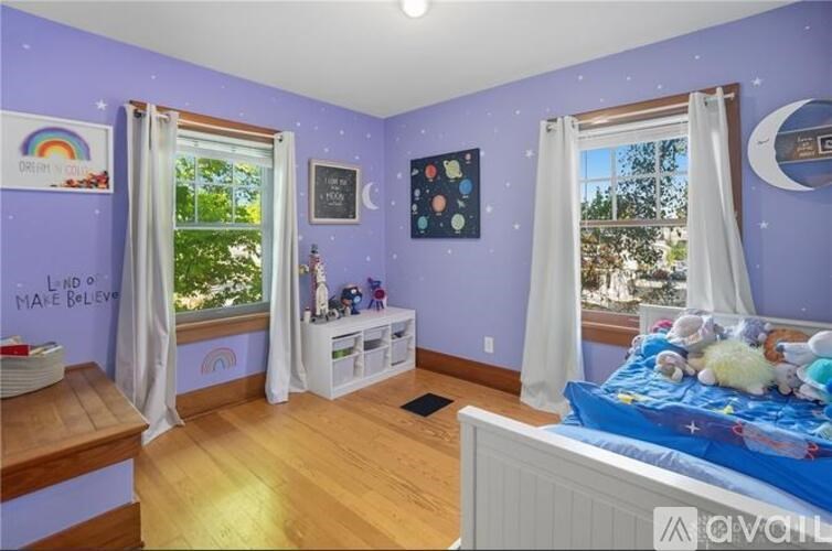 A child's bedroom with a bed, window, and toys.
