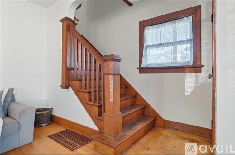 A wooden staircase with a window above it.