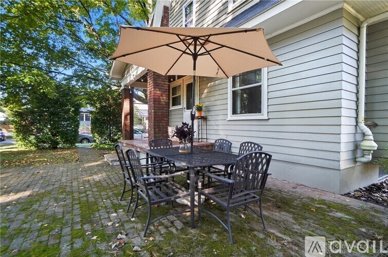 A patio with a table and chairs under an umbrella.