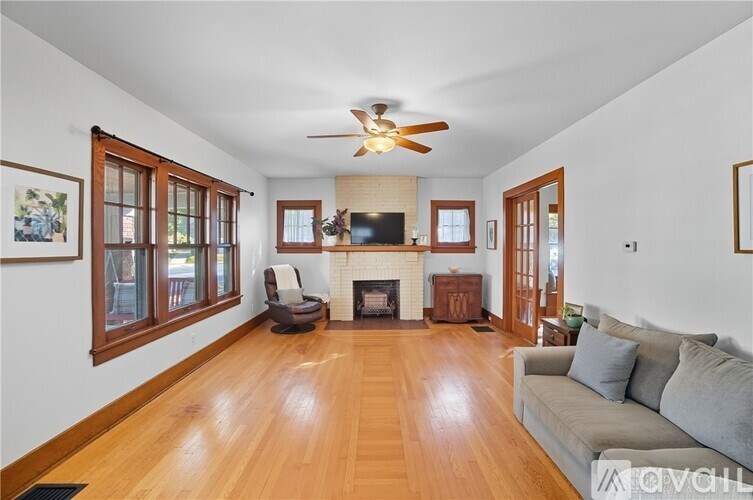 A living room with a grey couch and a fireplace.