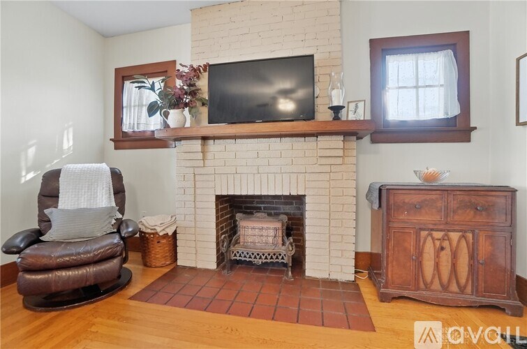 A living room with a brown leather chair and a fireplace.