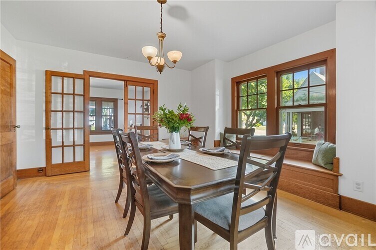 A dining room with a wooden table and chairs.