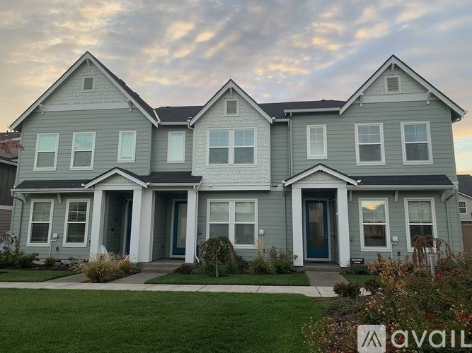 A house with a grey exterior and a sign that says "AVAILABLE" in front of it.