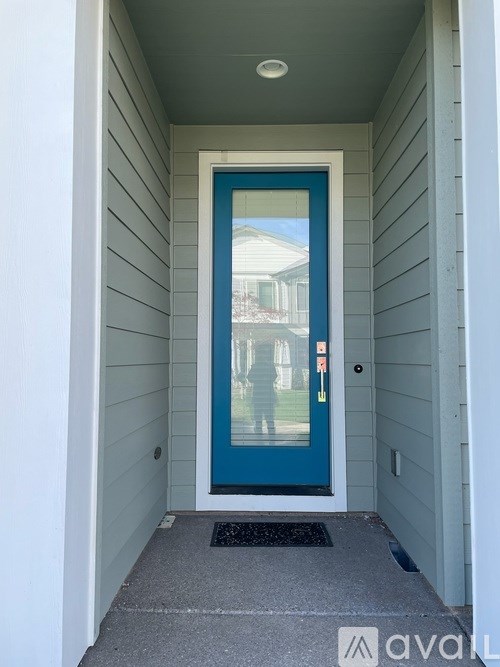 A blue door is in the middle of a white wall.