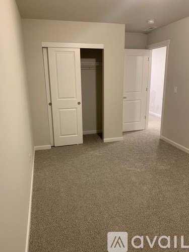 A room with a carpeted floor and a white door.