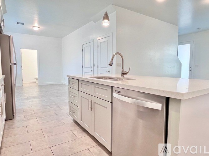 A kitchen with white cabinets and a stainless steel dishwasher.