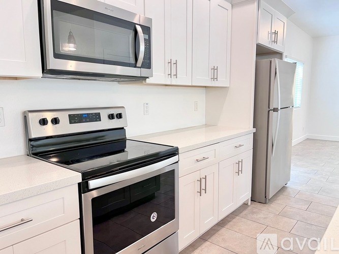 A kitchen with white cabinets and a black stove top oven.