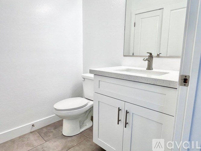A white toilet sits next to a sink in a bathroom.