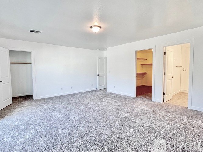 A large empty room with a carpeted floor and white walls.