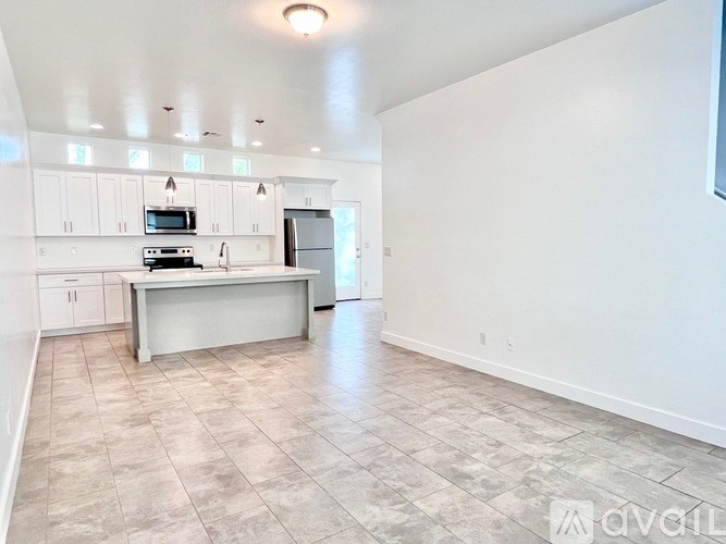 A kitchen with a refrigerator, microwave, and oven.