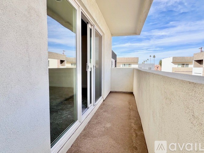 A balcony with a carpeted floor and sliding glass doors.