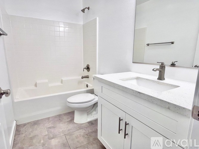 A white bathroom with a toilet, sink, and bathtub.