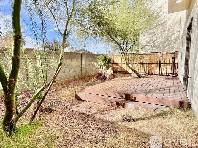 A backyard with a wooden deck and a fence.