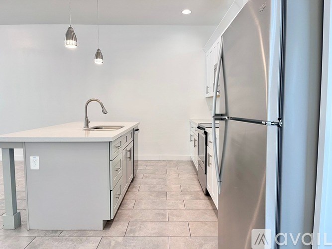 A kitchen with a white countertop and a stainless steel refrigerator.