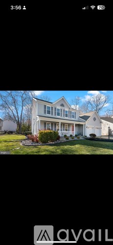 A house with a white exterior and a blue sky in the background.