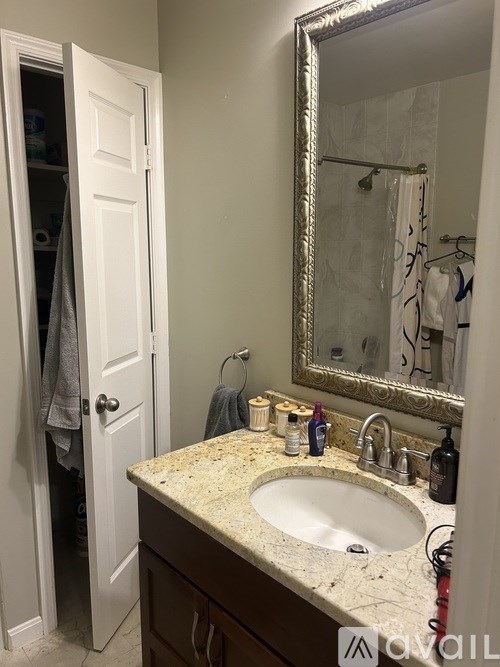 A bathroom with a sink, mirror, and towel rack.