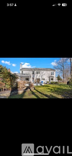 A house with a white facade and a green lawn.